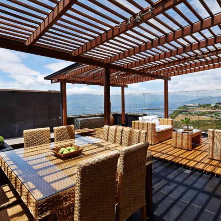 Vue sur une terrasse équipée d'une pergola en bois moderne, idéale pour comparer les avantages des pergolas bioclimatiques et traditionnelles dans l'aménagement extérieur.